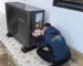 A man installing a black AC unit