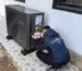 A man installing a black AC unit