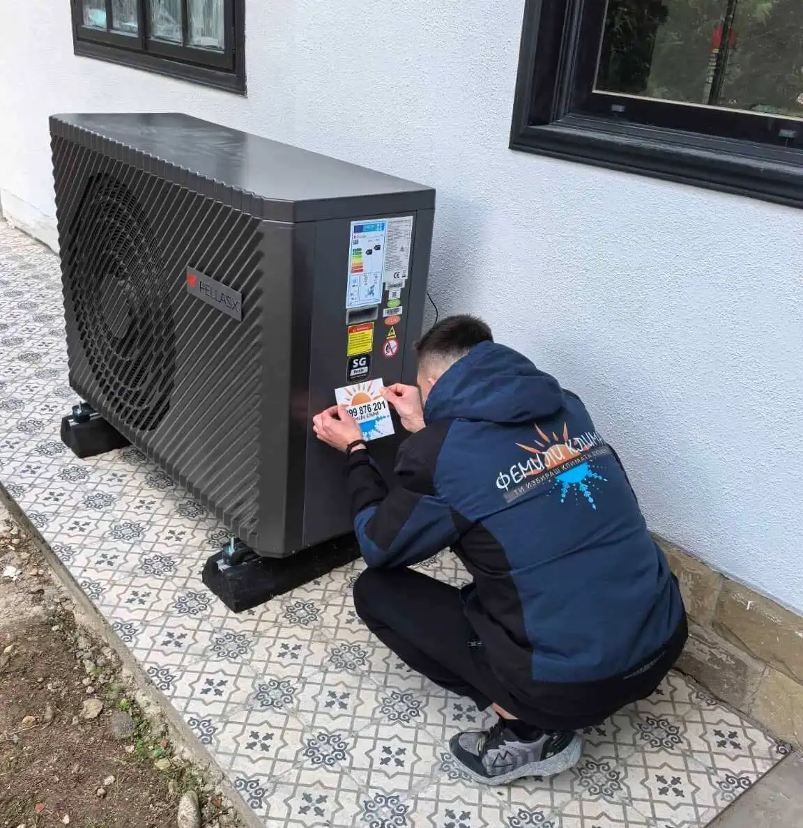 A man installing a black AC unit