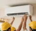 Men installing AC unit